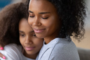 Mother hugging and comforting teen